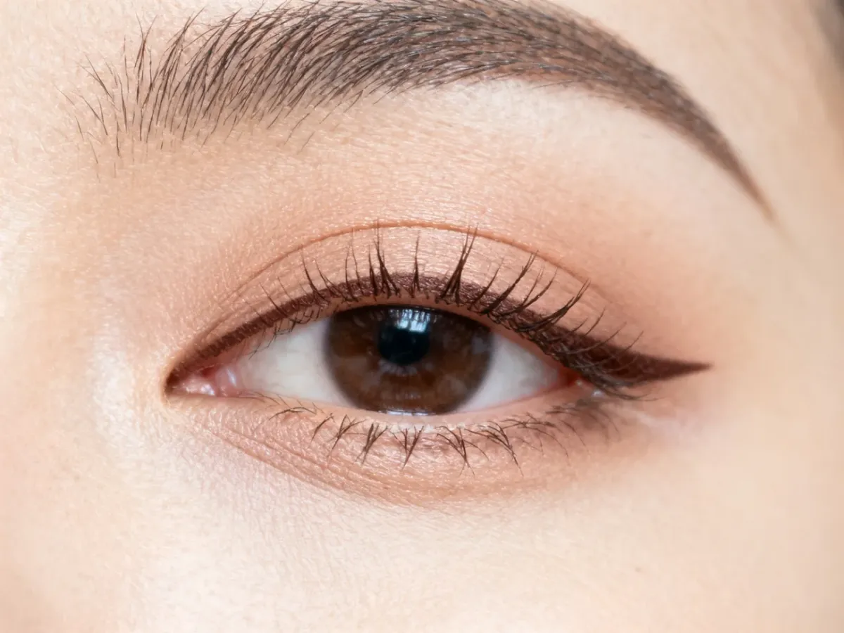 Tightlining between the upper eyelashes with a soft eyeliner pencil