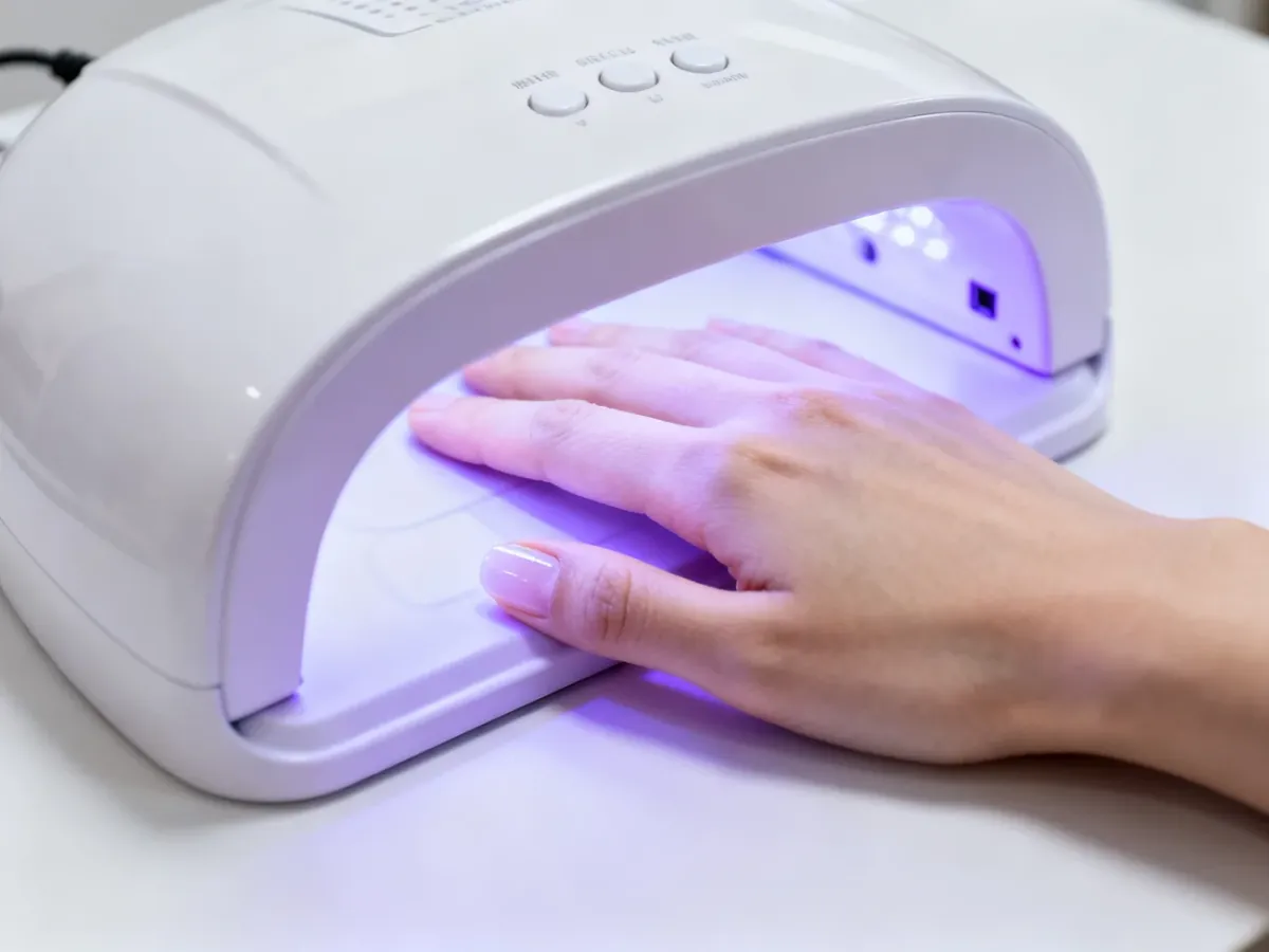 Dłoń podczas utwardzania żelu w lampie UV LED